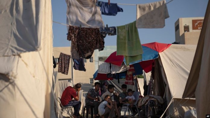 Palestinos desplazados por el bombardeo israelí de la Franja de Gaza se encuentran en un campamento de tiendas de campaña proporcionado por la ONU en Khan Younis, el jueves 19 de octubre de 2023.