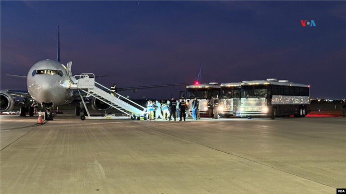 Migrantes venezolanos abordan el avión que los llevará desde Harlingen, Texas, hasta Caracas, Venezuela, en la madrugada del miércoles. Se trata del primer vuelo de deportación directa desde EEUU a territorio venezolano en más de cuatro años. [Fotografía: Laura Sepúlveda, VOA]