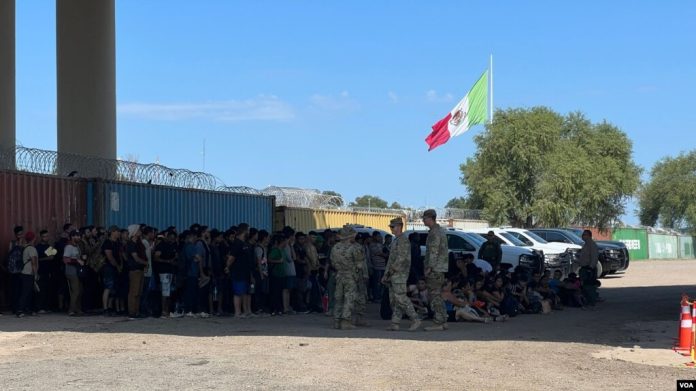ARCHIVO - Autoridades fronterizas agrupan a migrantes irregulares que se entregaron para ser procesados tras cruzar a Eagle Pass, Texas, el 29 de septiembre de 2023. (Salomé Ramírez, VOA)