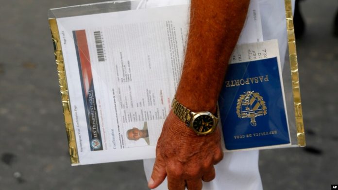 Un solicitante de visa estadounidense sostiene sus formularios del Departamento de Estado de Estados Unidos y su pasaporte cubano mientras espera en la fila frente a la entonces Sección de Intereses de EEUU -ahora embajada- en La Habana, el 1 de julio de 2015.