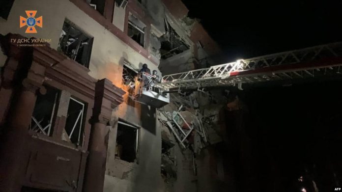 Esta fotografía publicada por el Servicio Estatal de Emergencia de Ucrania muestra a los rescatistas ucranianos trabajando en un edificio residencial parcialmente destruido después de los ataques con misiles rusos en Zaporizhzhia, el 18 de octubre de 2023.