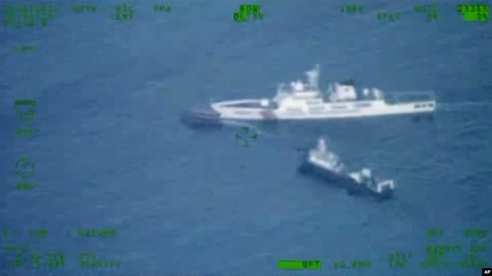 En esta imagen publicada por las Fuerzas Armadas de Filipinas, un barco de suministros filipino, arriba a la izquierda, navega cerca de un barco de la guardia costera china y un barco de la milicia china en el disputado Mar de China Meridional el domingo 22 de octubre de 2023.