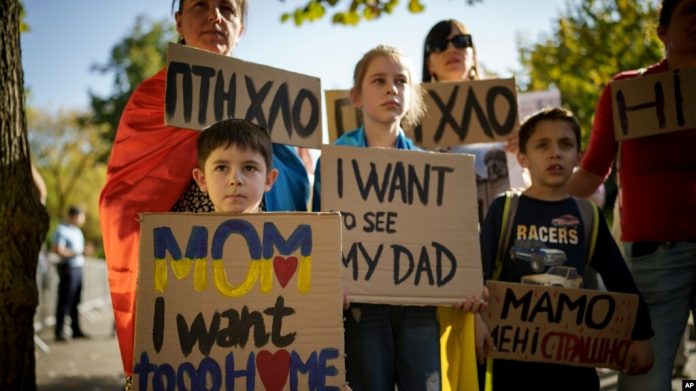 Niños ucranianos sostienen pancartas durante una protesta frente a la embajada rusa en Bucarest, Rumania, el sábado 14 de octubre de 2023.