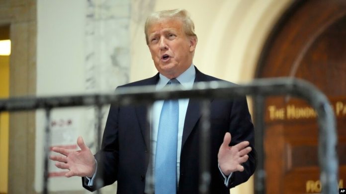 El expresidente Donald Trump habla mientras regresa a la sala del tribunal después de la pausa para el almuerzo de su juicio civil por fraude empresarial, el miércoles 18 de octubre de 2023, en la Corte Suprema de Nueva York, EEUU.
