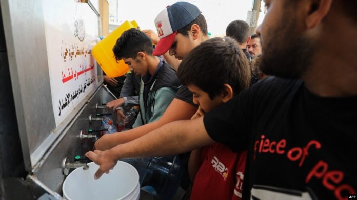 Palestininos llenan bidones de agua en la Ciudad de Gaza el 16 de octubre de 2023.