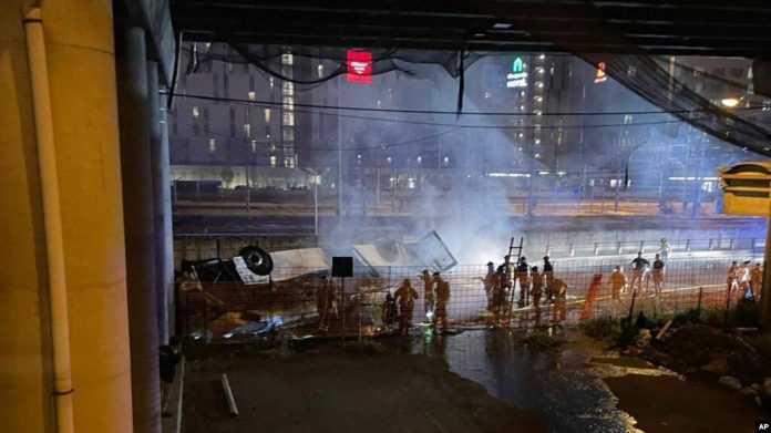 En esta imagen proporcionada por la Policía Estatal Italiana, agentes asisten a la escena de un accidente de autobús de pasajeros cerca de la ciudad de Venecia, Italia, que cayó desde una carretera elevada, el 3 de octubre de 2023.