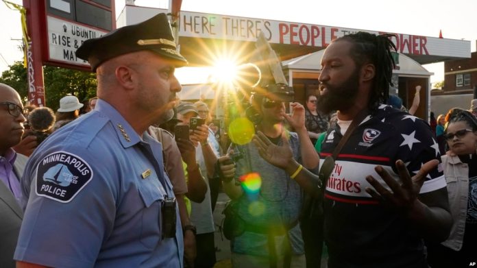 El jefe de policía de Mineápolis, Brian O'Hara, izquierda, habla con Michael Wilson, derecha, en el tercer aniversario de la muerte de George Floyd en la George Floyd Square de la ciudad de Mineápolis, el jueves 25 de mayo de 2023.