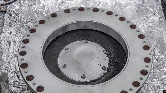 Esta fotografía proporcionada por la NASA el miércoles 11 de octubre de 2023 muestra la parte exterior del recolector de muestras Osiris-Rex con material del asteroide Bennu.