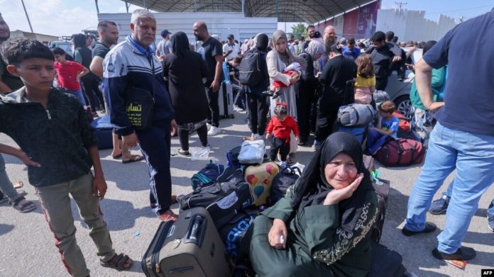 Palestinos, algunos con pasaportes extranjeros, tratan de cruzar hacia Egipto mientras otros esperan por ayuda en el cruce de Rafah, en el extremo sur de la Franja de Gaza, el 16 de octubre de 2023.